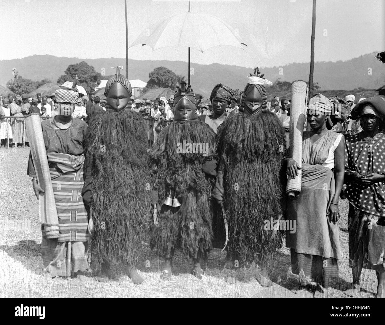 Bundu 'böse Tänzer' aus Freetown in Sierra Leone, gekleidet in Holzmasken und mit ihren Matten, auf denen sie auftreten, erwarten die Ankunft des Prinzen von Wales während seiner Afrikareise.23rd. April 1925. Stockfoto