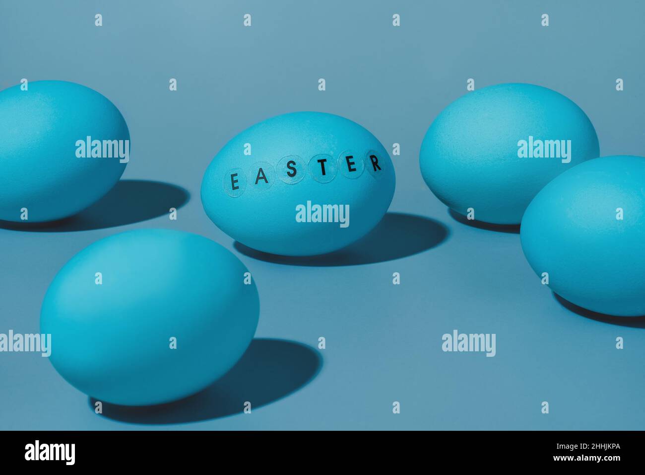 Fünf blaue Eier ein Ei mit dem Wort ostern darauf geschrieben Stockfoto