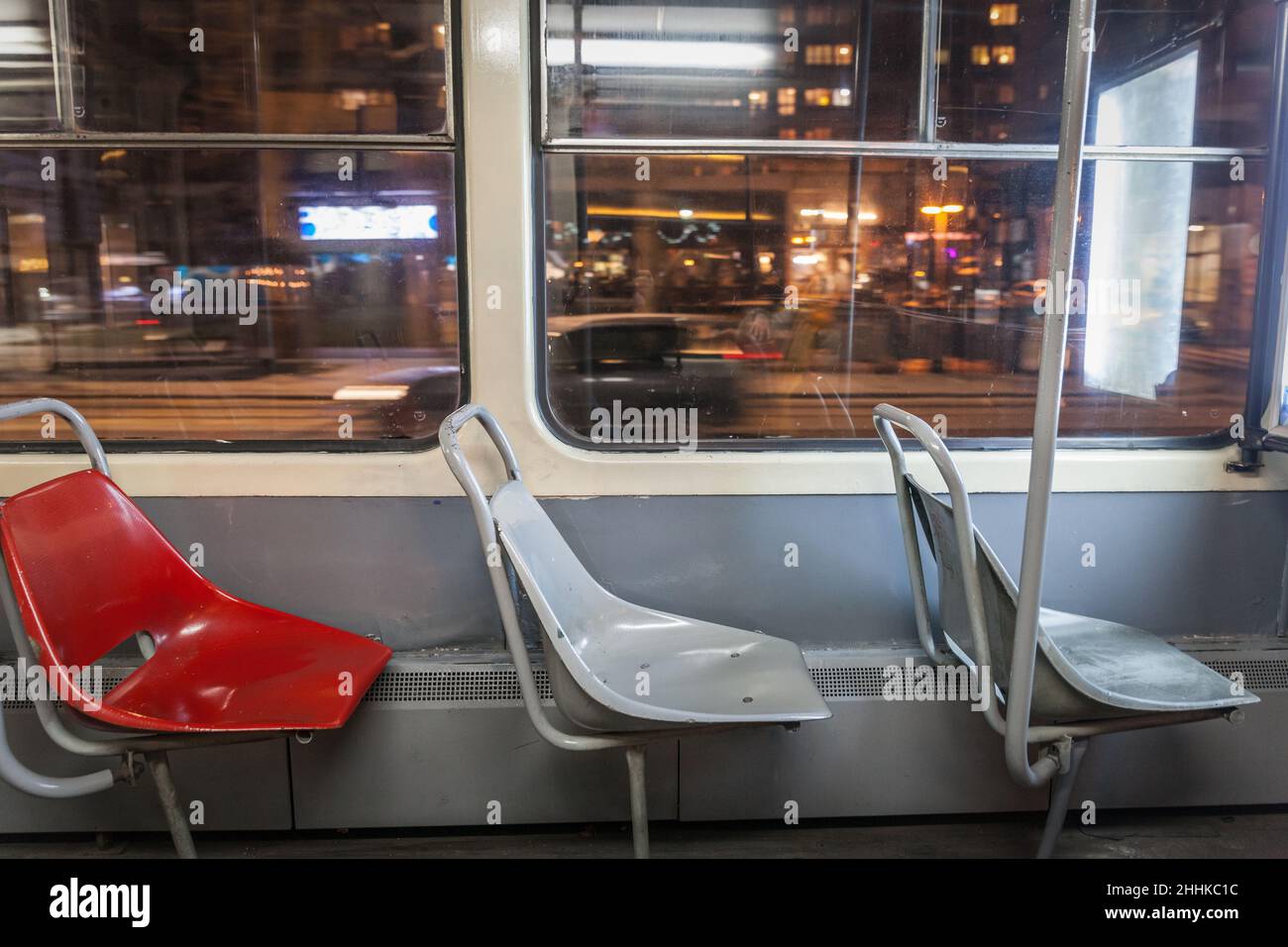 Bild von leeren Plastiksitzen in einem belgrader Straßenbahnwagen mit einer Geschwindigkeitswaschung im Hintergrund, nachts. Stockfoto