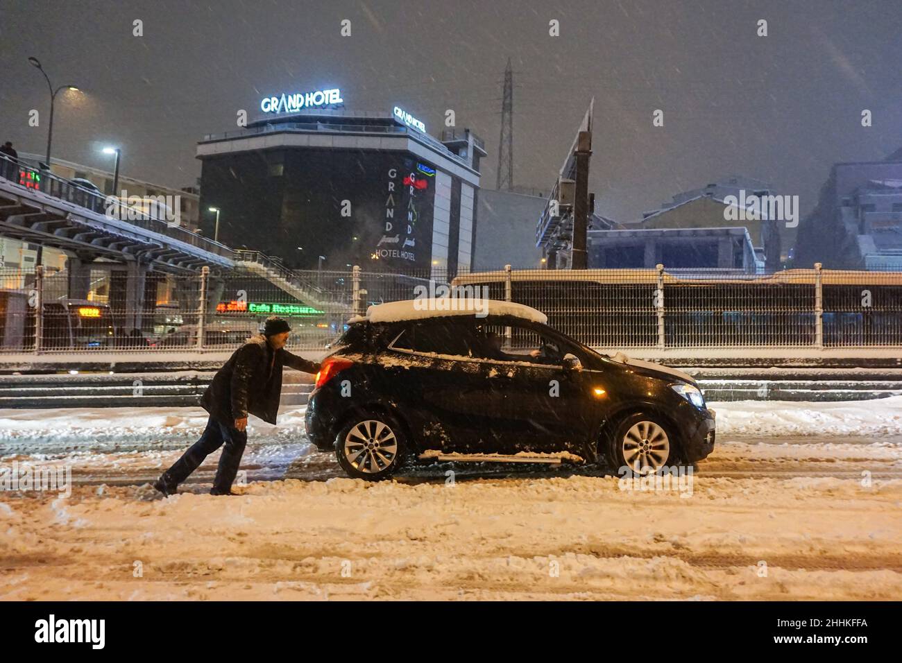 Ein Mann sah ein Auto auf einer schneebedeckten Straße schieben. Der Schneesturm, der in Istanbul am Abend ausbrach, brachte trotz der ergriffenen Maßnahmen das Leben zum Stillstand. Während die Metrobus-Verbindungen für kurze Zeit unterbrochen wurden, war die Autobahn D-100 am Standort Haramidere wegen des starken Schneefalls für den Verkehr gesperrt. Viele Fahrzeuge blieben stundenlang auf der Straße. Bürger mobilisierten, um die Fahrzeuge zu retten. Das Büro des Gouverneurs von Istanbul warnte die Fahrer, dass sie die Stadt nicht von Thrakien aus betreten könnten, einer Region, die sich über den europäischen Teil der Türkei bis zur westlichen Grenze zu Bulgarien und Griechenland erstreckt. Stockfoto