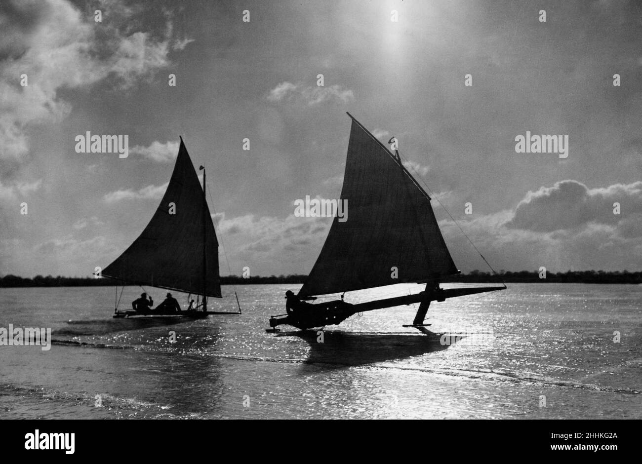 Eissegeln ist der Sport von Segel- und Renneisbooten, auch Eisyachten genannt.1911 wurden moderne Eisyachten aus einem einteiligen Rückgrat über die gesamte Länge des Bootes und einer Runner-Planke gefertigt, auf der es rechtwinklig ruht, wobei die beiden einen kiteförmigen Rahmen bildeten. Die besten Hölzer für diese Stücke sind Bassholz, Butternut und Kiefer. Sie werden so aus dem Holz geschnitten, dass sich das Herz des Holzes ausdehnt, was den Brettern eine permanente Kurve gibt, die im fertigen Boot nach oben gedreht wird. Bild zeigt: Ice Yachting in den Norfolk Broads. 2nd. März 1929 Stockfoto