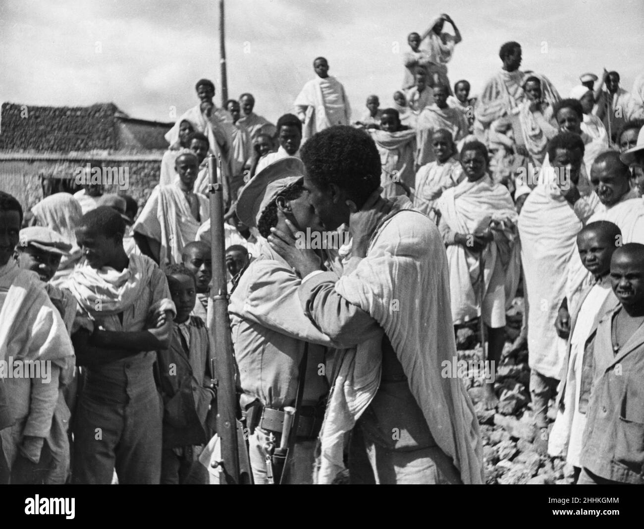 Abessinischer Krieg September 1935The die äthiopische Bauernarmee und ihre Frauen sahen sich hier auf dem Marktplatz von Harah auf der langen Fahrt mit dem Lastwagen zur Ogadan-Front im Süden des Landes versammeln. Ein Abschied der Soldaten, Männer küssen sich, wie die Franzosen, auf jede Wange. Stockfoto