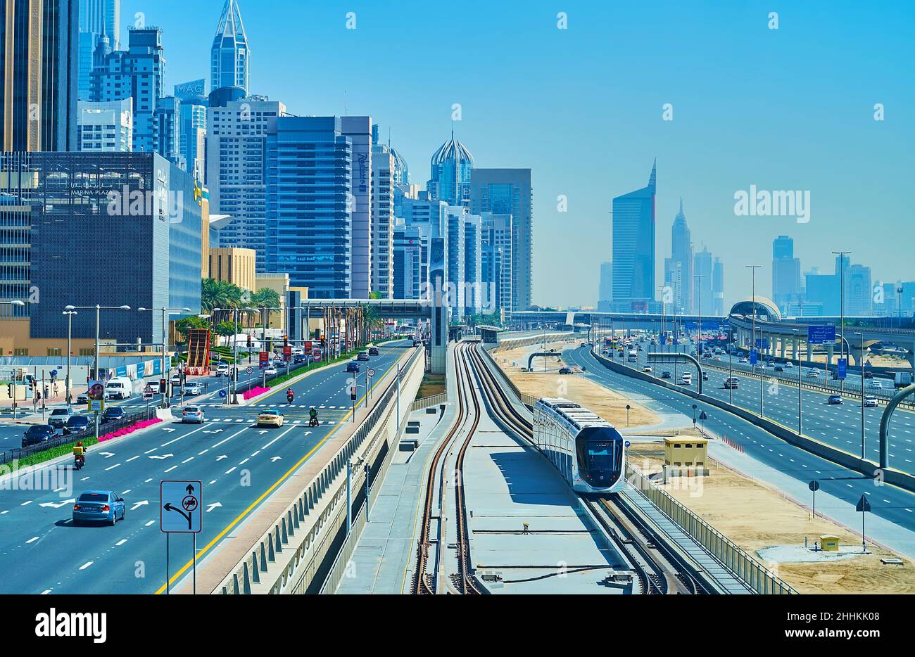 DUBAI, VAE - 7. MÄRZ 2020: Der Blick auf die fahrende moderne Straßenbahn, den schnellen Verkehr und den Arenco Tower der Dubai Internet City im Hintergrund, am 7. März in Stockfoto
