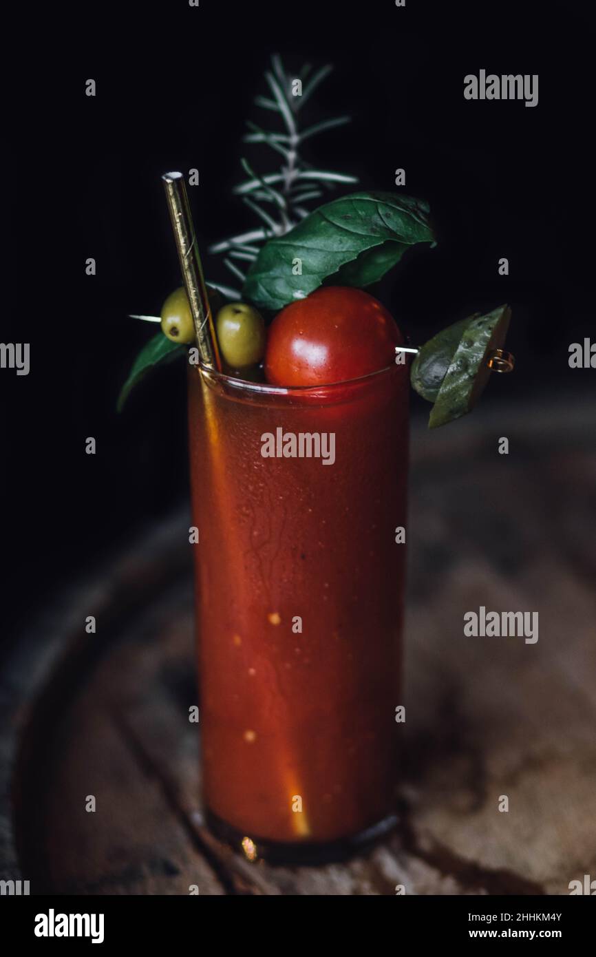 Single Bloody Mary Drink Cocktail mit goldenem Trinkhalm und vielen Garnierungen Stockfoto
