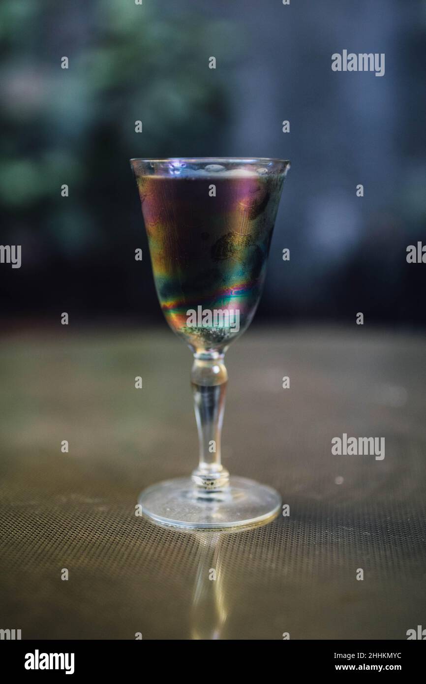 Schillerndes schwarzes Limonade-Cocktailgetränk am Abend mit goldenem Messingtisch Stockfoto