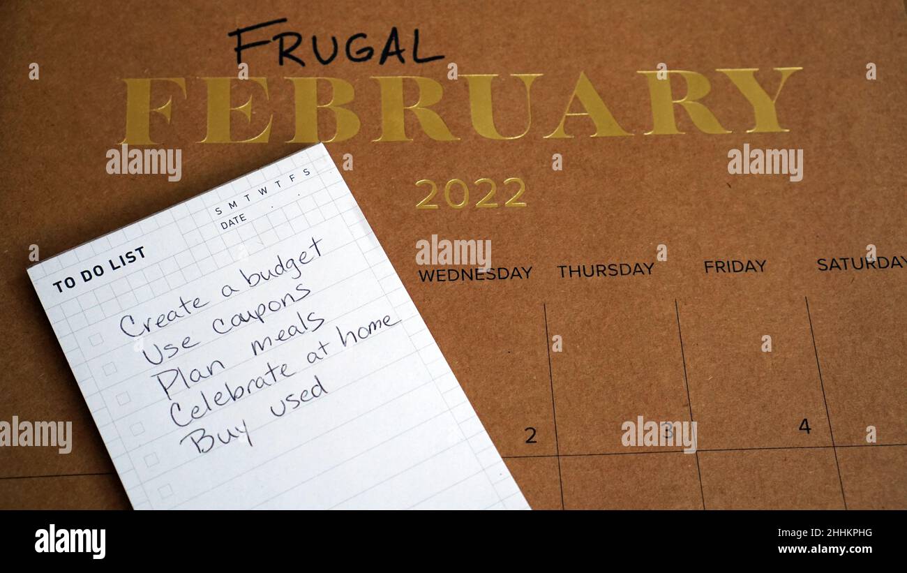 Sparsamer Februar auf dem Kalender zusammen mit einer Liste von Tipps geschrieben. Die Idee hinter Frugal February ist, zu versuchen, so billig wie möglich zu leben. Stockfoto