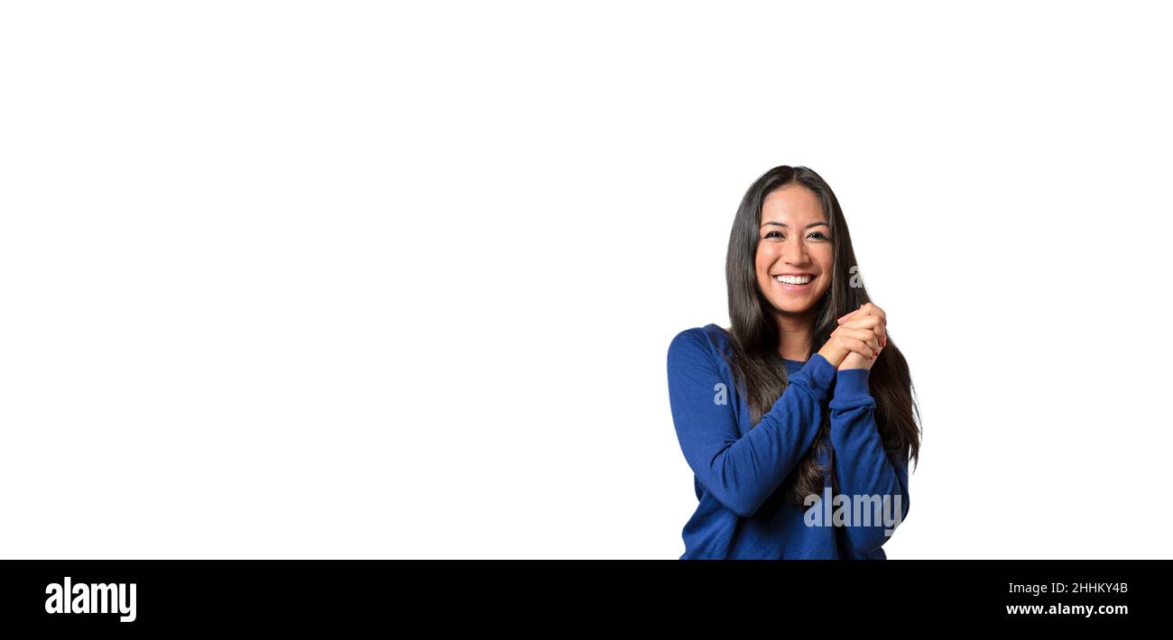 Glückliche junge Frau mit einem schönen Lächeln und zusammengekrallten Händen, die auf einem weißen Hintergrund mit Copyspace posieren Stockfoto