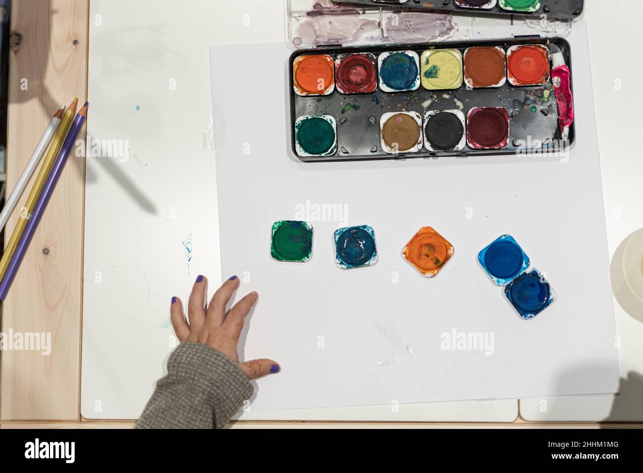 Bunte Palette mit weißem Papier Leinwand und Kinderhand bereit, zu malen beginnen Stockfoto