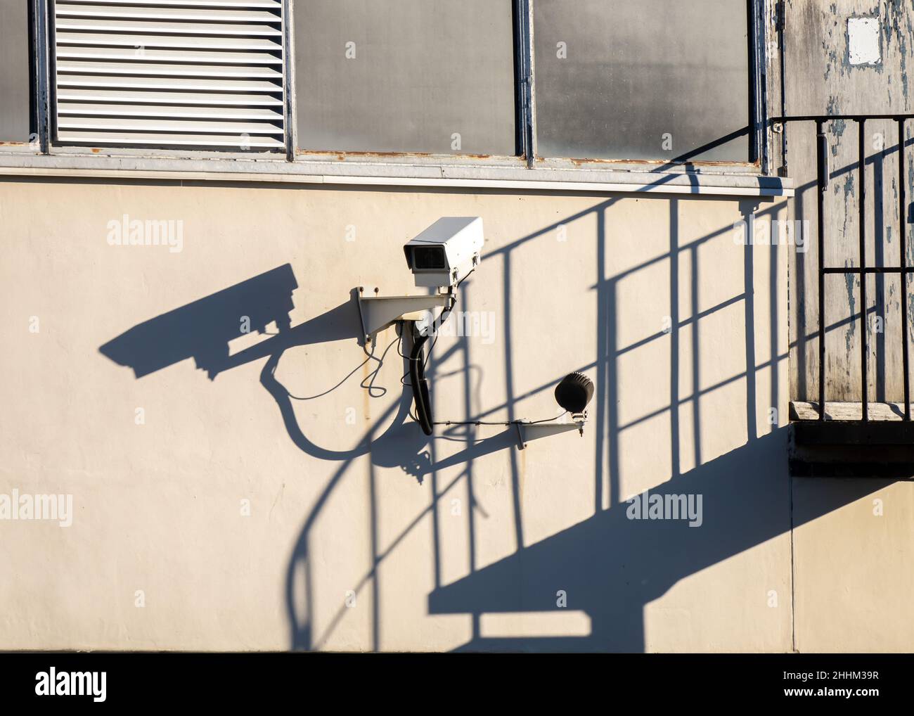 Professionelle CCTV-Kamera mit Schattenwurf an der Gebäudewand. Hochsicherheitsbereich mit geschlossener Fernsehkamera, Treppenhaus Industrie Stockfoto