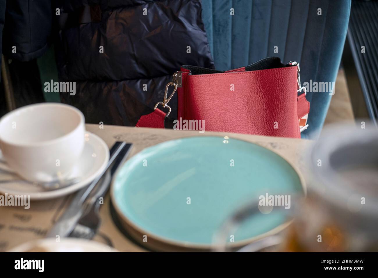 Rote Dame Handtasche unbeaufsichtigt auf einem Stuhl im Restaurant gelassen, Innenaufnahme Stockfoto