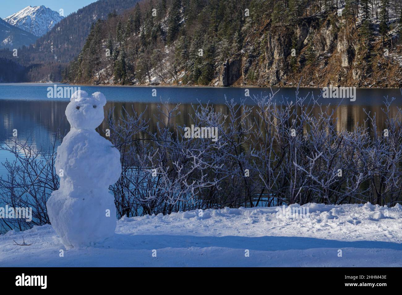 Kinder haben am Ufer des Alpsee in Schwangau, Bayern, einen Schneemann gebaut. Stockfoto