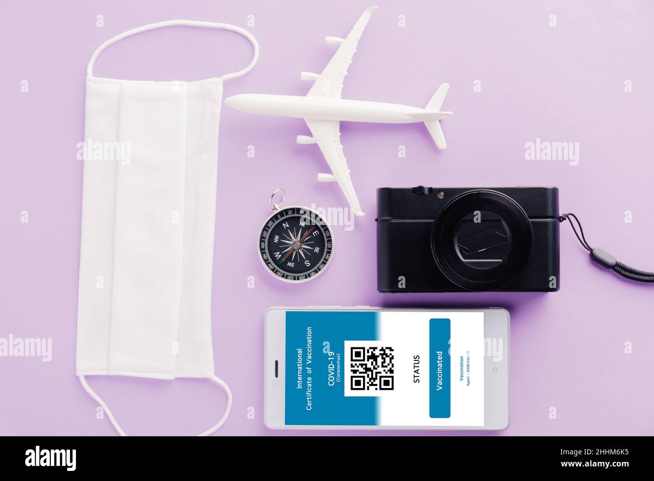 Modellflugzeug, Kamera, Gesichtsmaske und Immunität Pass Anwendung auf  Smartphone auf lila Hintergrund, Travel Concept während Covid-19 Pandemie  digital in Stockfotografie - Alamy