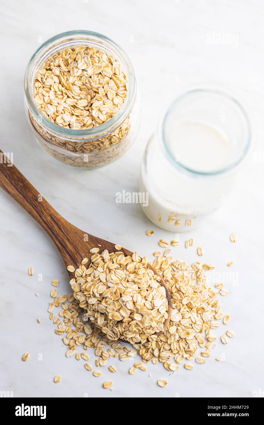 Frühstückscerealien. Ungekochte Haferflocken. Rohe Haferflocken in Holzlöffel. Draufsicht. Stockfoto