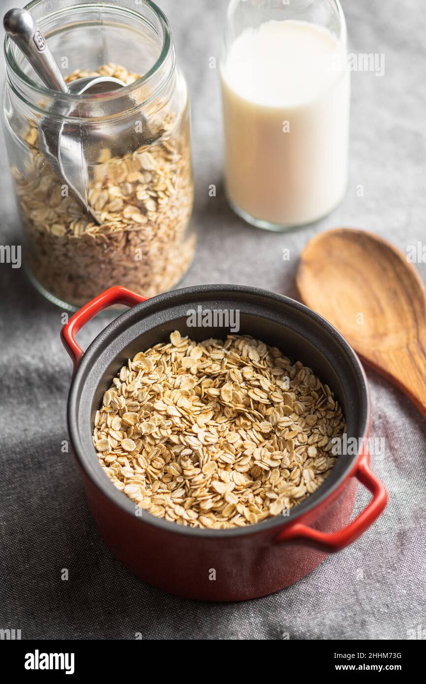 Frühstückscerealien. Ungekochte Haferflocken. Rohe Haferflocken im Topf. Stockfoto