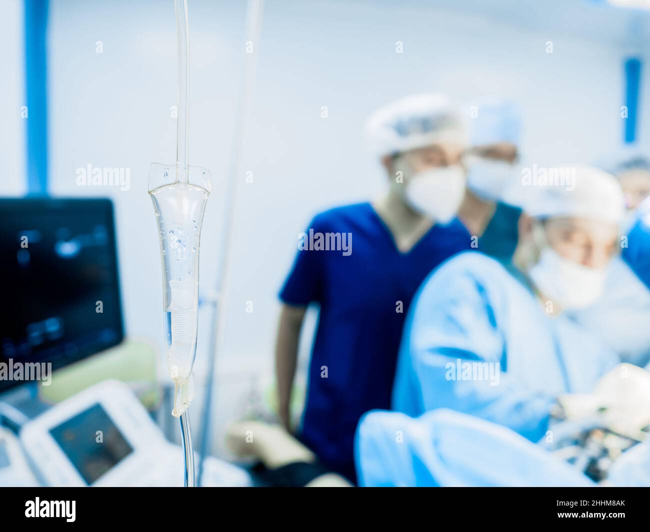 Selektiver Fokus auf ein transparentes Röhrchen eines medizinischen Tropfers mit Kochsalzlösung aus nächster Nähe. Auf einem verschwommenen Hintergrund, Operation. Stockfoto