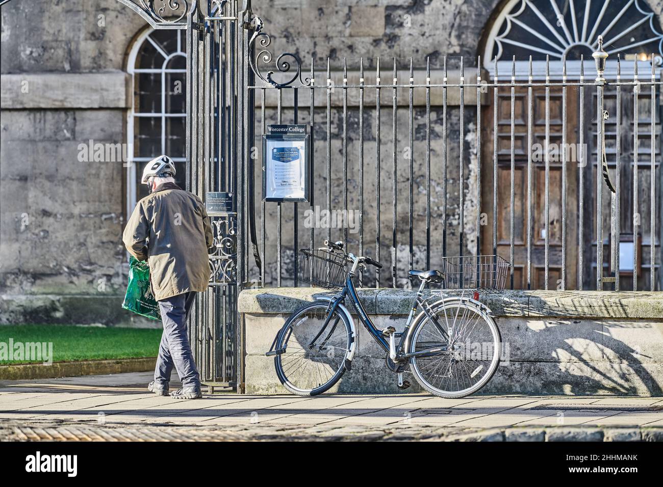 Ein Kollege parkt sein Fahrrad auf den Schienen und geht zum Worcester College, Universität von Oxford, England. Stockfoto