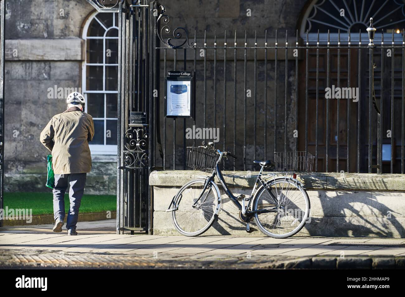 Ein Kollege parkt sein Fahrrad auf den Schienen und geht zum Worcester College, Universität von Oxford, England. Stockfoto