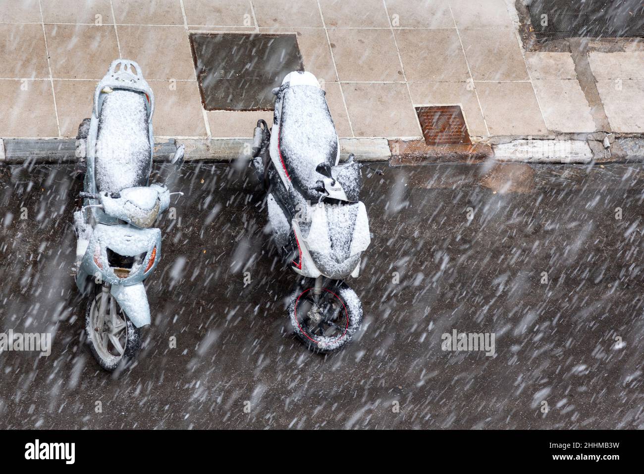 Motorräder, die bei Schneefall in Athen im Januar 24th 2022 geparkt wurden. Stockfoto