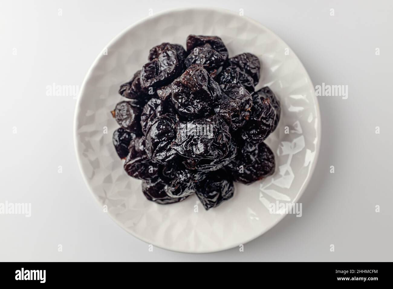 getrocknete Pflaumen auf weißem Hintergrund Stockfoto