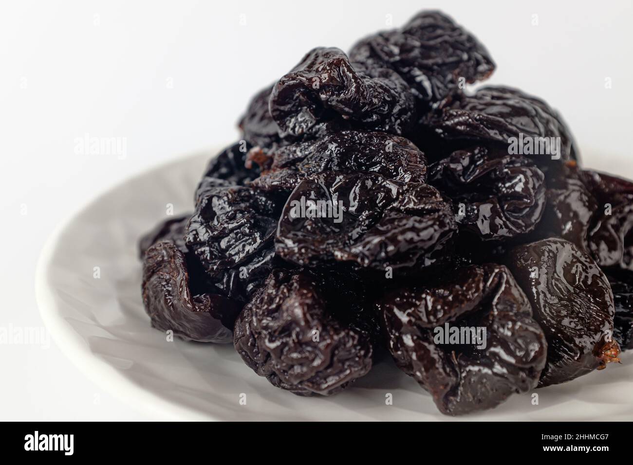 getrocknete Pflaumen auf weißem Hintergrund Stockfoto