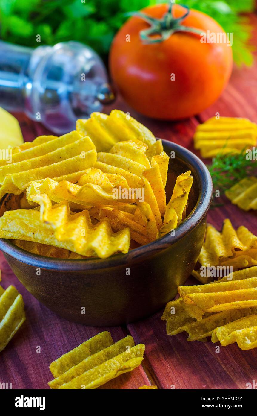 Gebratene Kartoffelchips auf dem Tisch und Zutaten Stockfoto