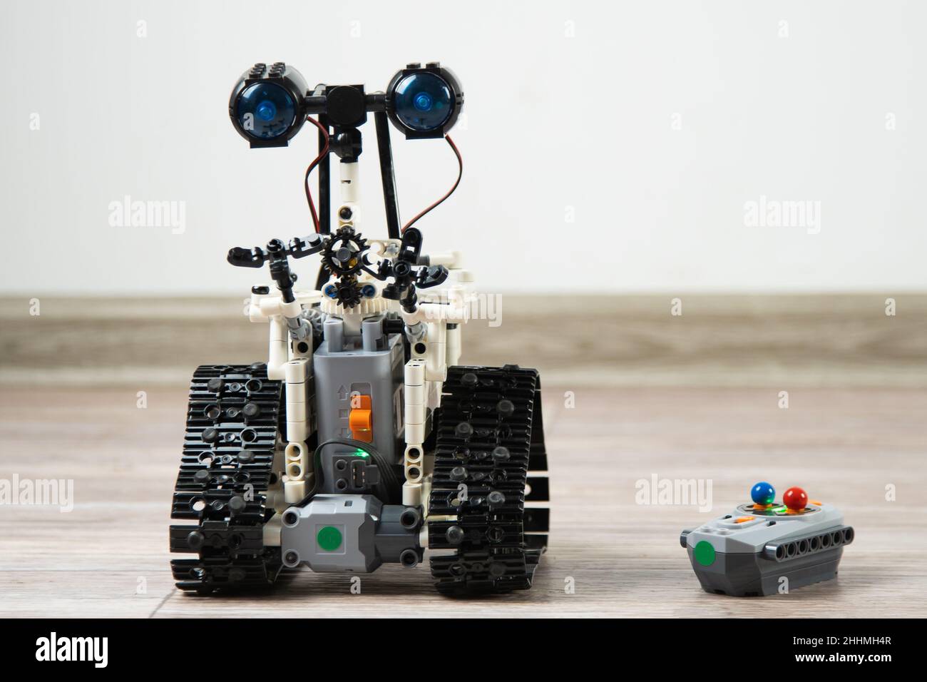 Der Roboter vom Kinderdesigner auf dem Bedienfeld. DIY Lernspielzeug. Ein funkgesteuerter Roboter fährt auf dem Boden. Robotik in Aktion. Roboter aus dem Konstruktor. Stockfoto