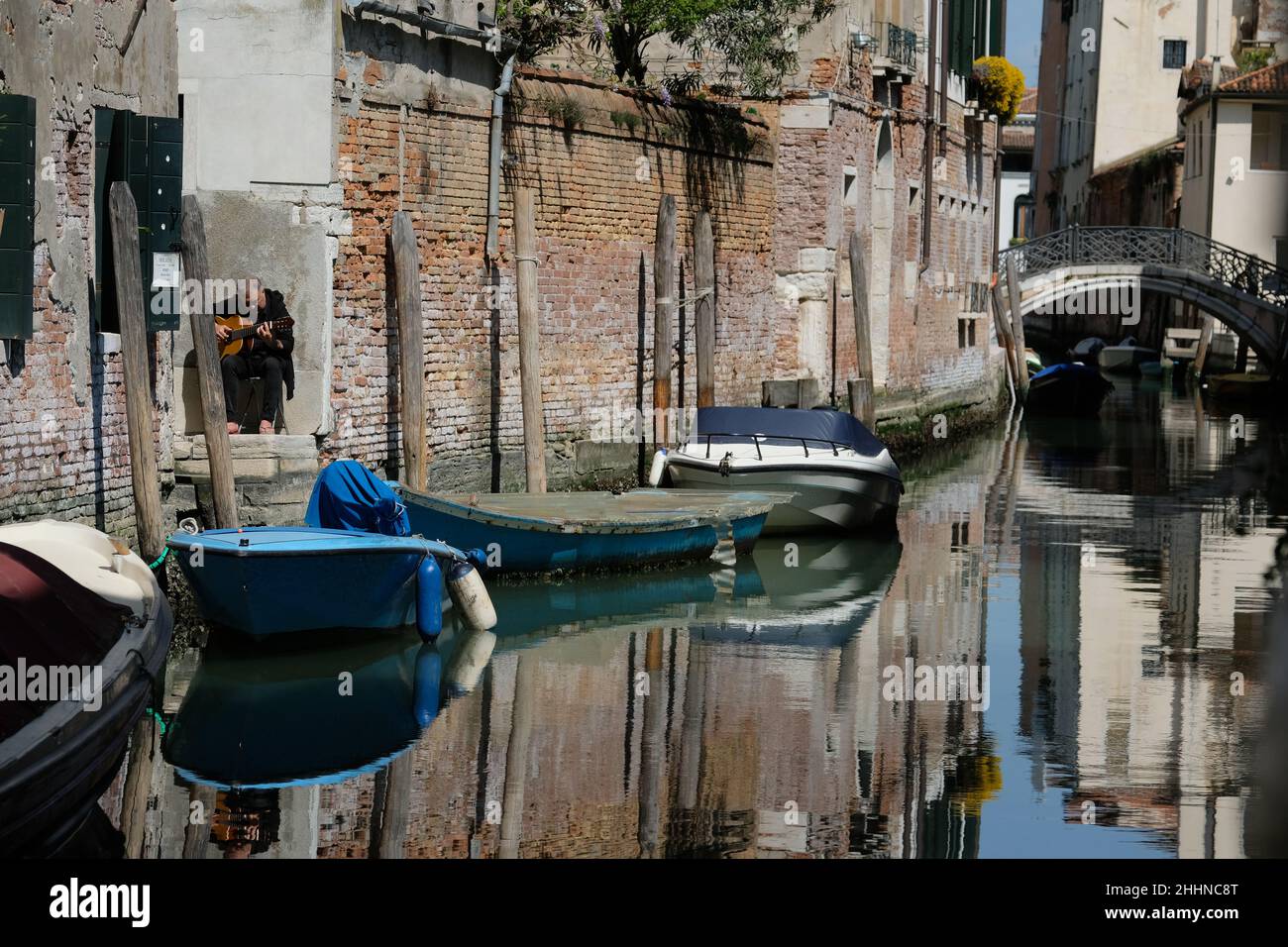 Ein Mann spielt seine Gitarre entlang eines Kanals in Venedig Stockfoto