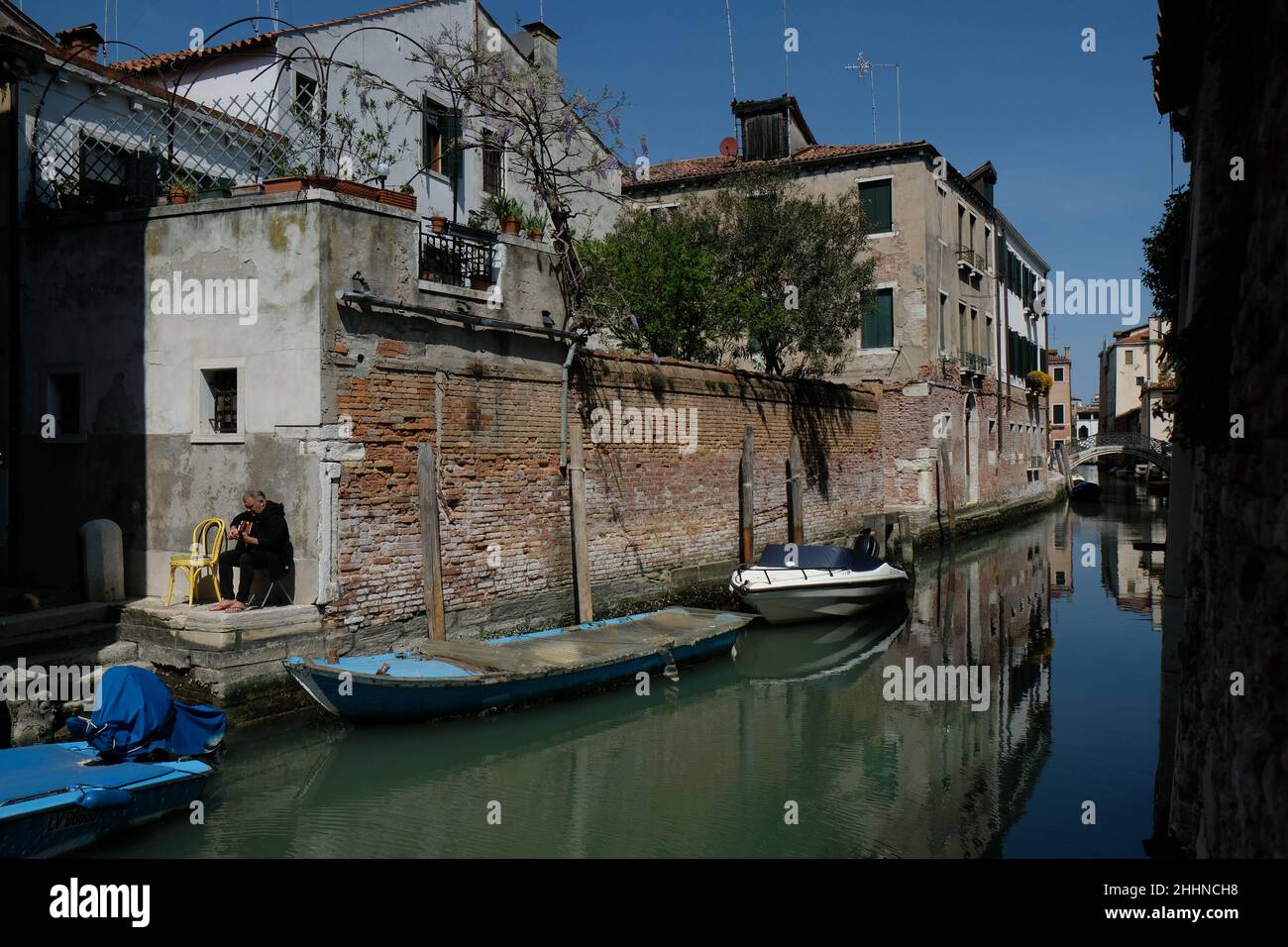Ein Mann spielt seine Gitarre entlang eines Kanals in Venedig Stockfoto