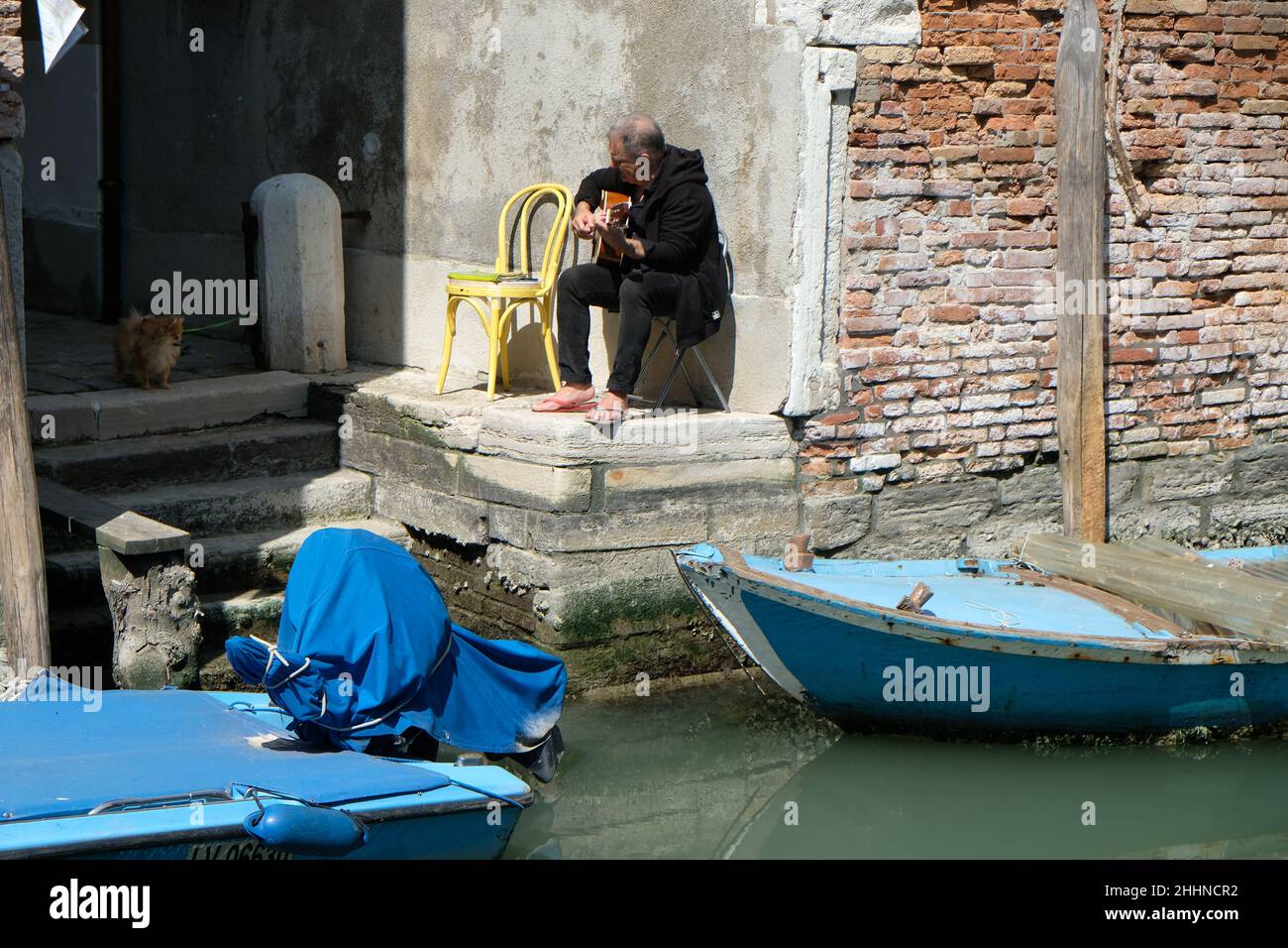 Ein Mann spielt seine Gitarre entlang eines Kanals in Venedig Stockfoto