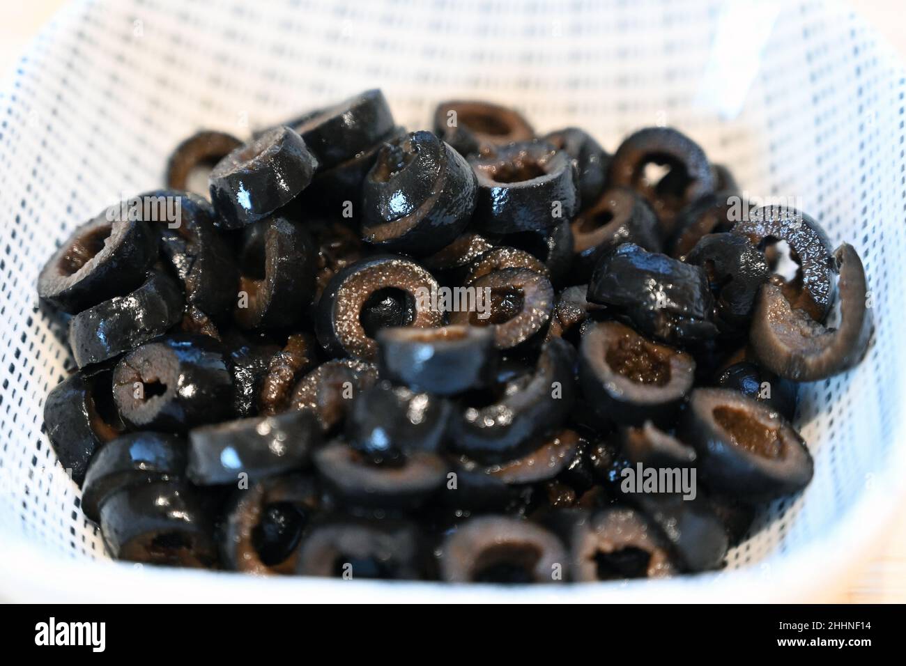 Schwarze Oliven in Scheiben geschnitten, Zutaten zum Kochen, Zubereitung von Speisen Stockfoto