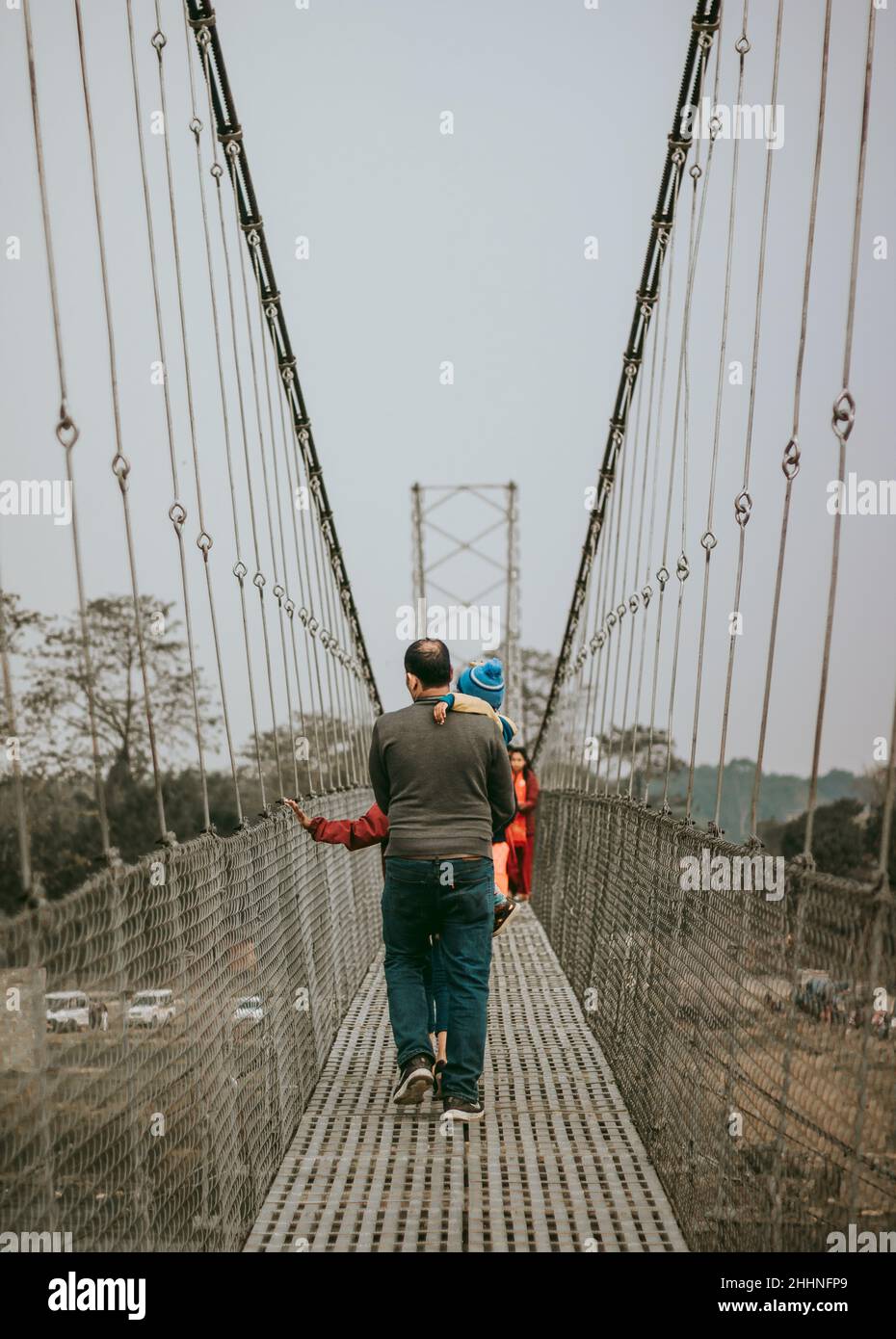 Mann in grüner Jacke und schwarzer Hose, der auf der Brücke läuft Stockfoto