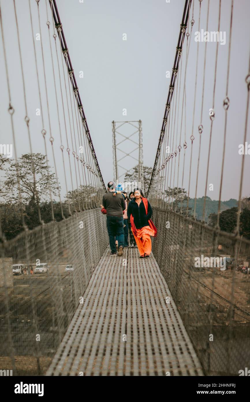 Mann in grüner Jacke und schwarzer Hose, der auf der Brücke läuft Stockfoto