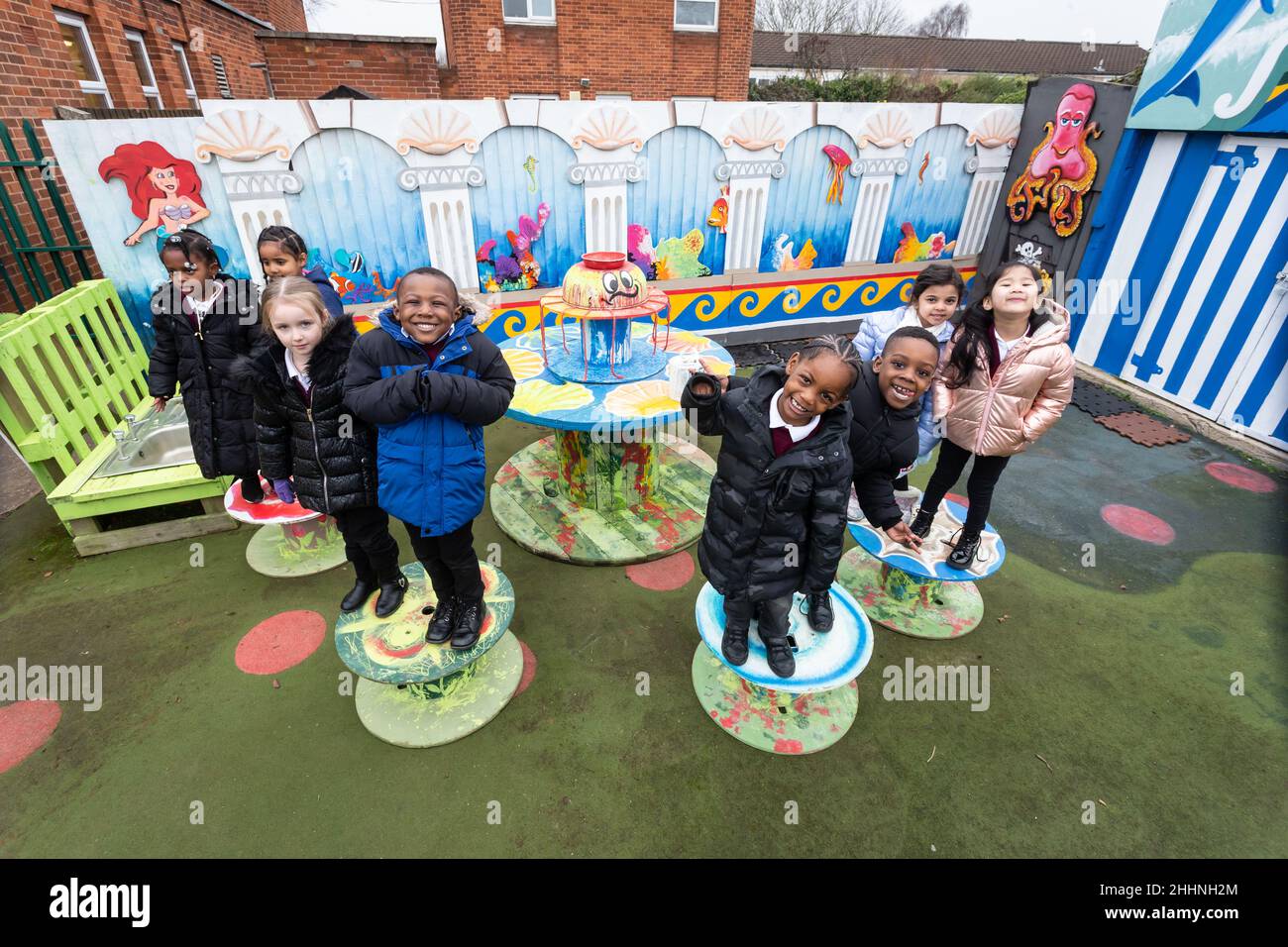 Birmingham, Großbritannien. 25th Januar 2022. Kinder der RC-Grundschule von St. Edmund, Spring Hill, Birmingham, mit dem von dem Künstler Terry Glazebrook gemalten Spielplatzgemälde, das geschaffen wurde, um den langweiligen Blick auf die Innenstadt von Birmingham zu erhellen, die der Fertigstellung nähert. Laut einer Studie der Schools Week war die psychische Gesundheit die zweithäufigste unter den führenden Politikern (42 Prozent). Kinder aus innerstädtischen Gebieten gelten als am stärksten von psychischen Problemen bedroht. Kredit: Peter Lopeman/Alamy Live Nachrichten Stockfoto