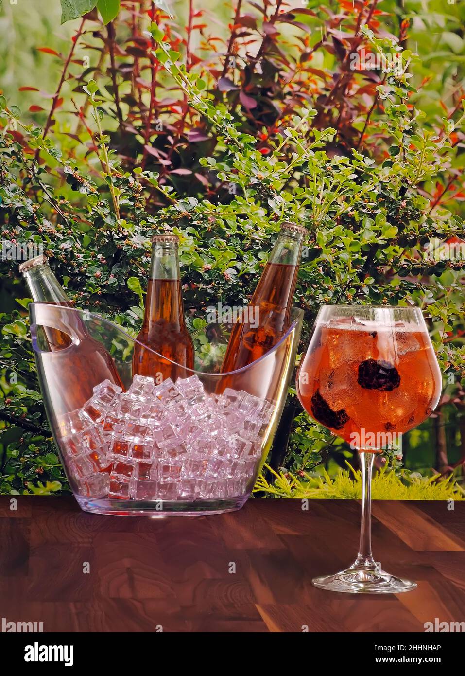 Flaschen und ein Glas Apfelwein mit Brombeergeschmack auf einem Gartenhintergrund Stockfoto