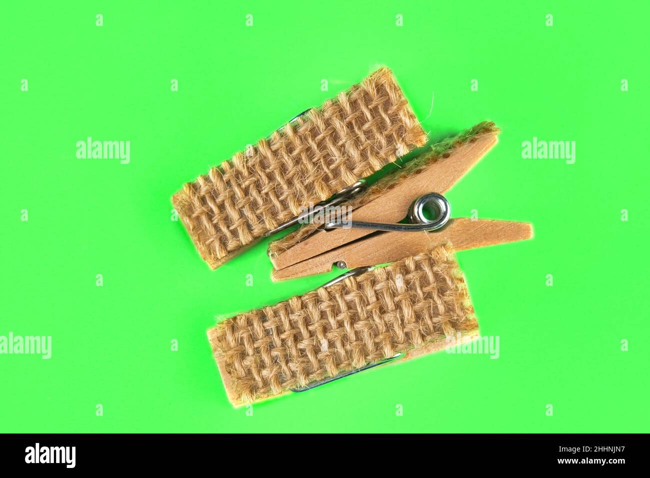 Drei kleine Wäscheklammern auf grünem Hintergrund Stockfoto