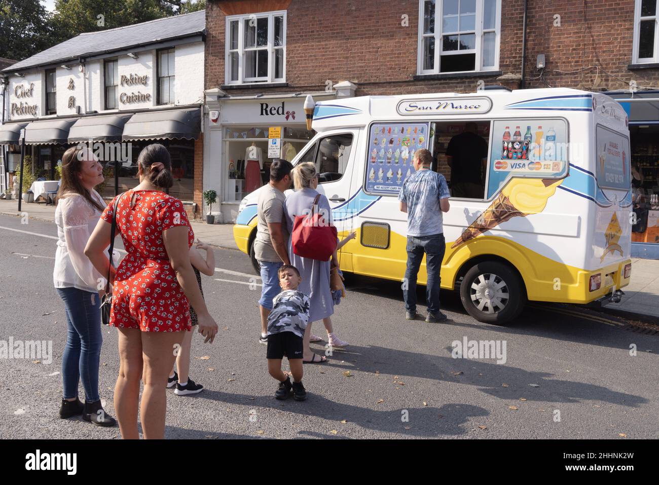 Soziale Distanzierung im Vereinigten Königreich; Menschen, die während der COVID 19-Pandemie in Harpenden Hertfordshire in einem Eiswagen Schlange stehen, um Eis zu kaufen Stockfoto