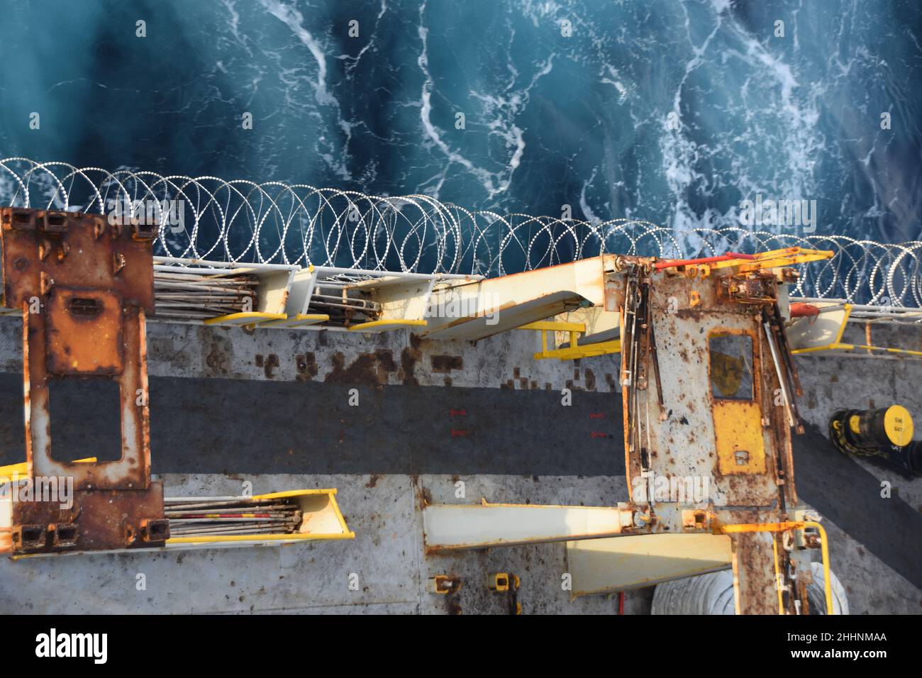 Scharfer Stacheldraht oder Stacheldraht aus Edelstahl, der an Schiffsrumpf, Überbau und Geländer befestigt ist, um die Besatzung vor Piratenangriffen zu schützen. Stockfoto