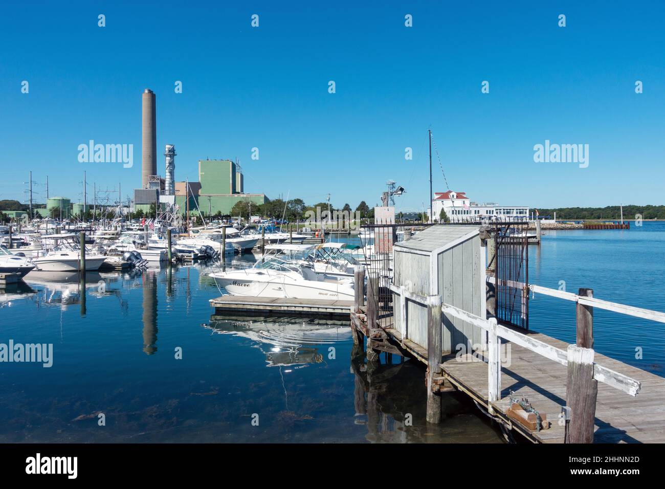 Sandwich Marina auf Cape Cod, Massachusetts, mit vielen angedockten Booten und einem Kraftwerk dahinter Stockfoto