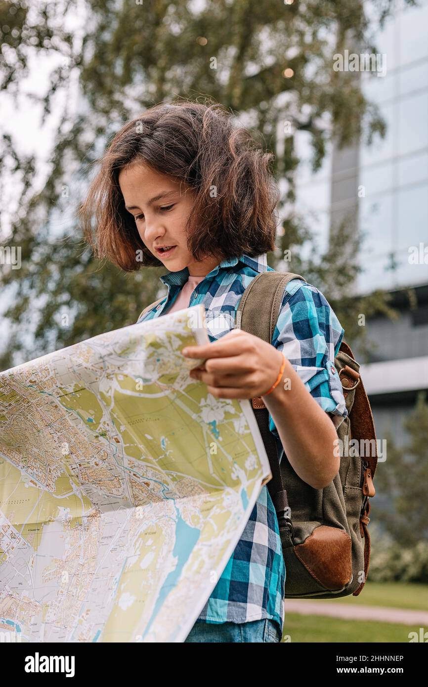 Hipster junges Mädchen schaut auf die Karte. Nette Brünette teen Mädchen reist im Sommerurlaub. Vertikale Aufnahme Stockfoto