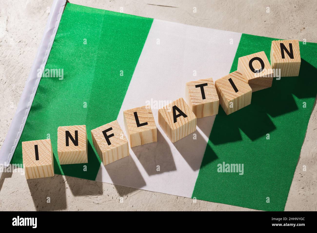 Flagge und Holzwürfel mit Text, Konzept zur Inflation in Nigeria Stockfoto