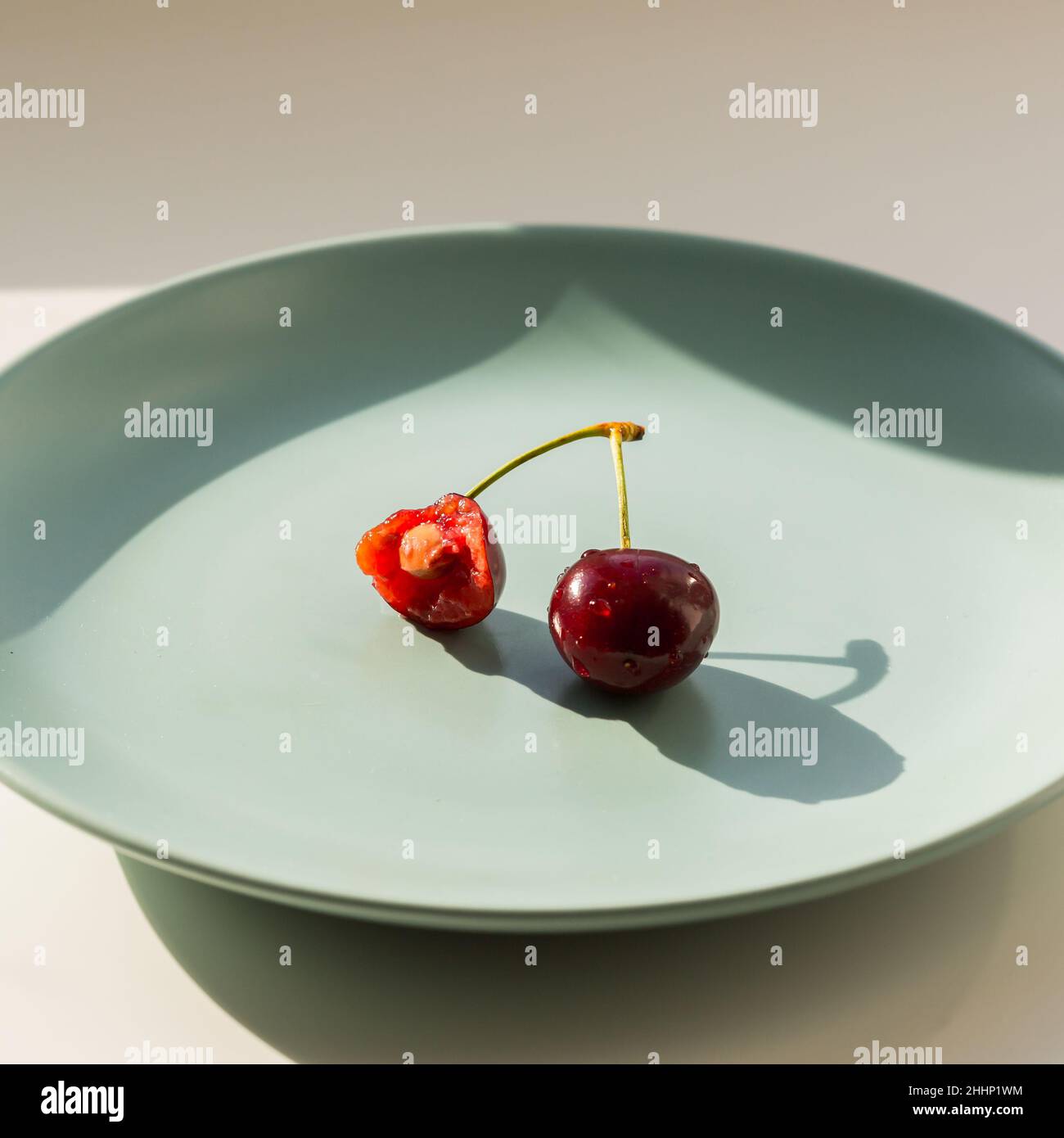 Eine rote Erdbeere auf dem grünen Teller. Gesundes Lifestyle-Konzept. Stockfoto