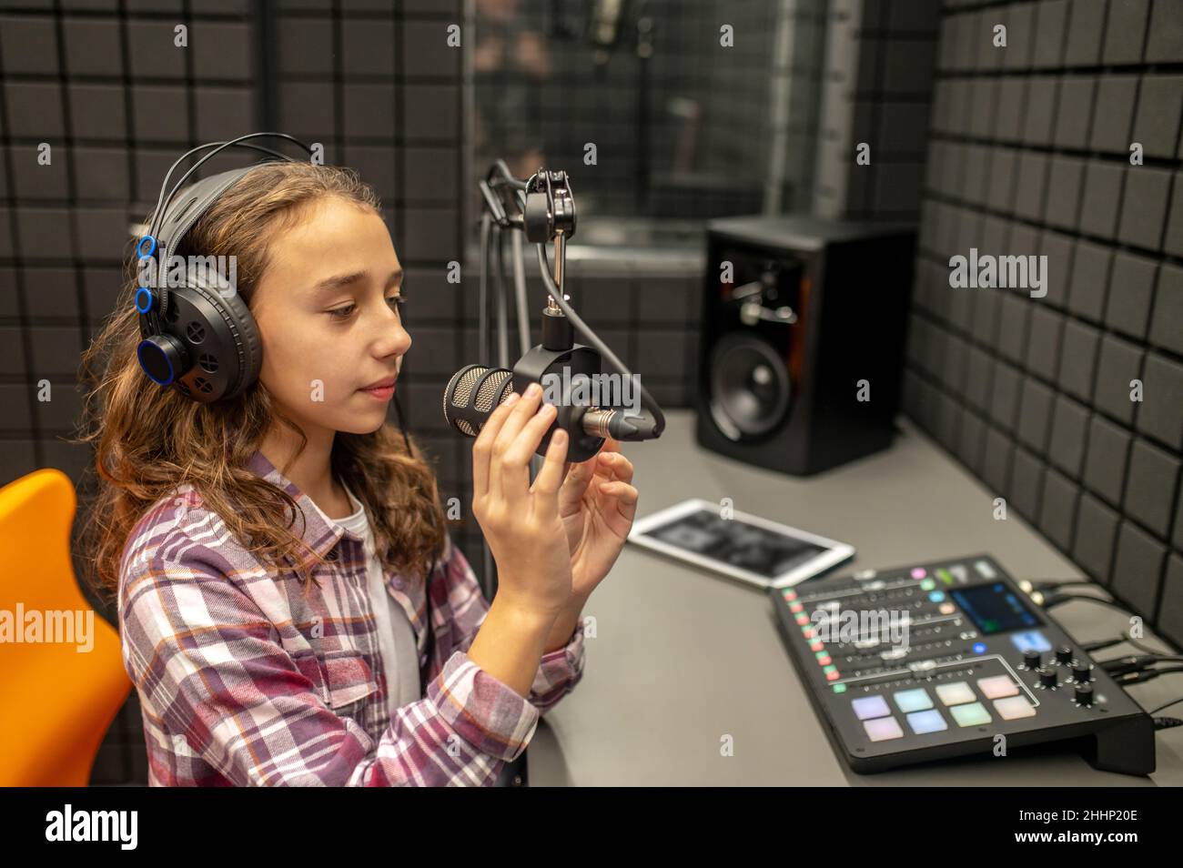 Teenager-Mädchen überprüft ihr mike, bevor sie einen Podcast aufnehmen Stockfoto