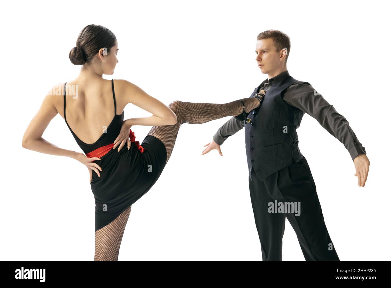 Nahaufnahme zwei junge Tänzer, Mann und Frau tanzen argentinischen Tango isoliert auf weißem Studiohintergrund. Künstler in schwarzen Bühnenkostümen Stockfoto
