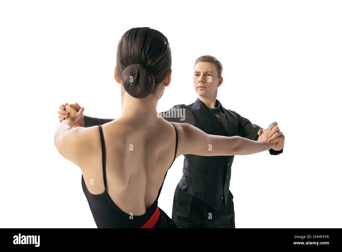 Nahaufnahme zwei junge Tänzer, Mann und Frau tanzen argentinischen Tango isoliert auf weißem Studiohintergrund. Künstler in schwarzen Bühnenkostümen Stockfoto