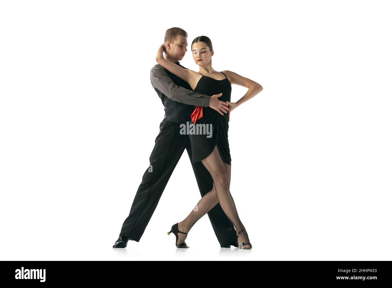 Anmut und schöne Tänzer, junges Paar, das argentinischen Tango tanzt, isoliert auf weißem Studiohintergrund. Künstler in schwarzen Bühnenkostümen Stockfoto