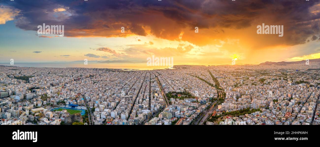Luftdrohne Panoramablick auf die griechische Hauptstadt Athen bei Sonnenuntergang mit einem Himmel bedeckt mit Sturmwolken, Griechenland, Europa. Blick auf die Stadt von oben Stockfoto