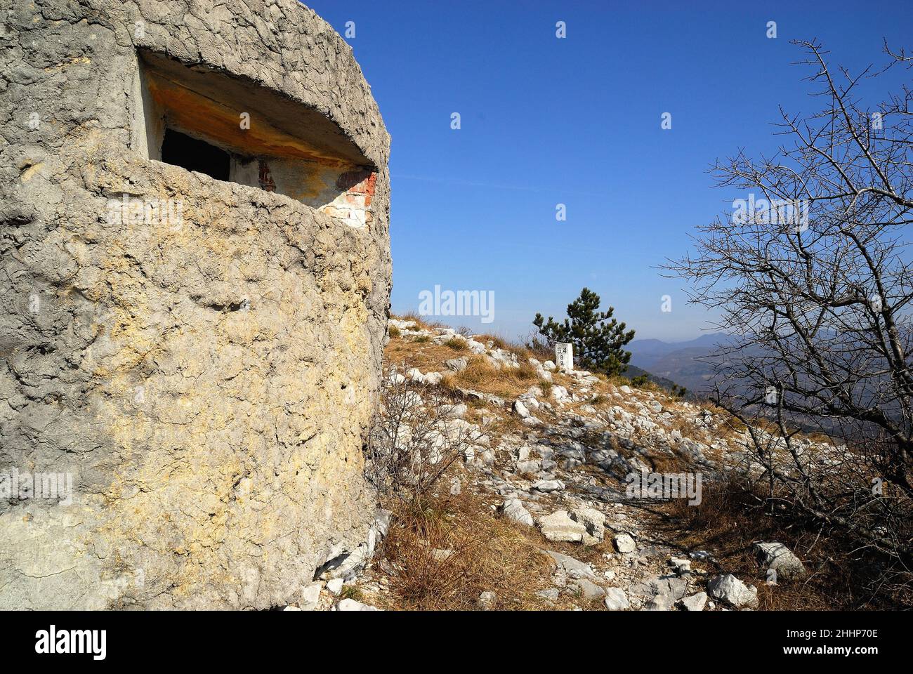 Der unzugängliche Kamm des Monte Sabotino (Sabotin) blickt über das enge Tal des Flusses Isonzo (Soca). Die dicht bepflanzten weißen Pfosten und der Bunker markieren die Grenze zwischen Italien und Slowenien und erinnern uns daran, dass in den Jahren des Kalten Krieges der Eiserne Vorhang entlang dieser Linie verlief. Stockfoto
