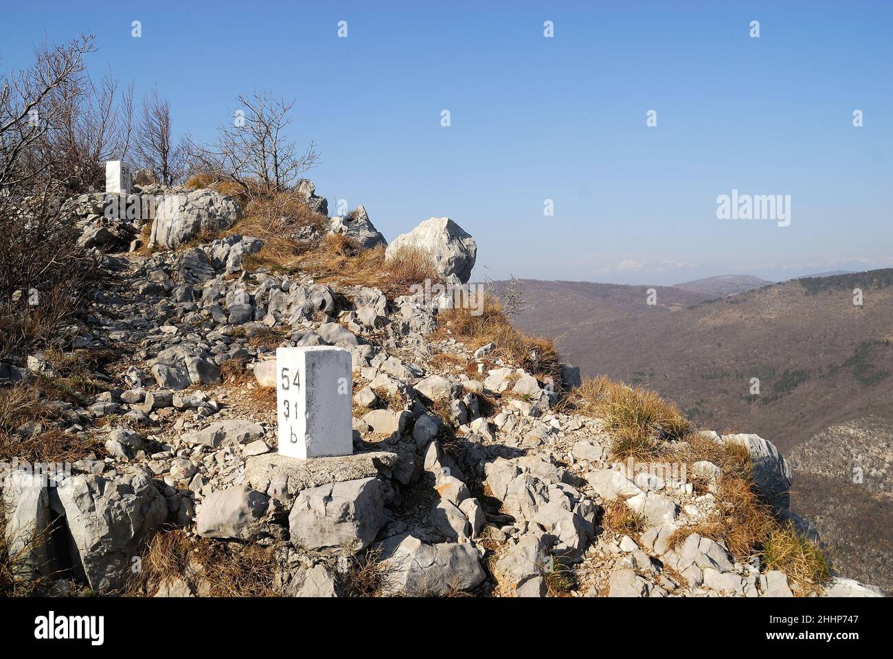Der unzugängliche Kamm des Monte Sabotino (Sabotin) blickt über das enge Tal des Flusses Isonzo (Soca). Die dicht gepflanzten weißen Pfosten markieren die Grenze zwischen Italien und Slowenien und erinnern uns daran, dass in den Jahren des Kalten Krieges der Eiserne Vorhang auf dieser Linie verlief. Stockfoto