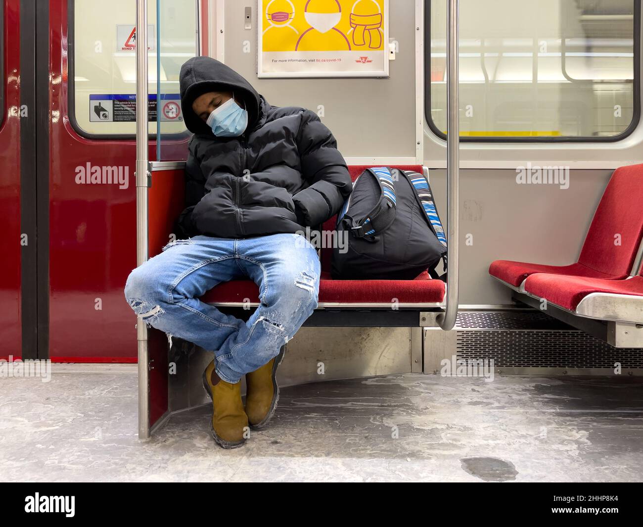 Toronto, Kanada, 22. Januar 2022: Ein Mann, der in einem U-Bahn-Zug mit Schutzmaske schläft Stockfoto