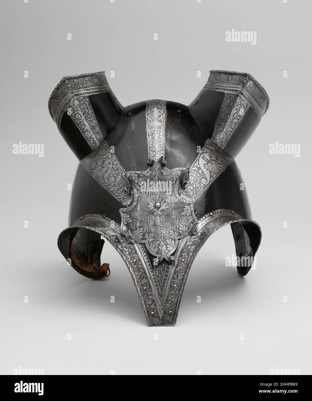 Halb-Shaffron (Verteidigung des Pferdekopfes) ca. 1553 Deutsch, möglicherweise Braunschweig der Shaffron besteht aus einer Hauptplatte, die sich in der Mitte der Nase zu einem tiefen, stumpfen Punkt verjüngt, mit kräftigen Flanschen über den Augen und tief gewölbten Seiten. Die Ohrenschützer sind getrennt, ebenso die Aufsteckplatte; die Abstimmplatte fehlt. Die Kanten werden gedreht und umzogen. Die geätzte Dekoration, die in Bändern um die Ränder angeordnet ist und in drei Bändern zusammenläuft, die in der Mitte der Hauptplatte zum Escutcheon hinunterlaufen, besteht aus rollendem Laub, Füllhorn, Vasen und einem unverwechselbaren grotesken Motiv, das einen Schlitz umfasst Stockfoto